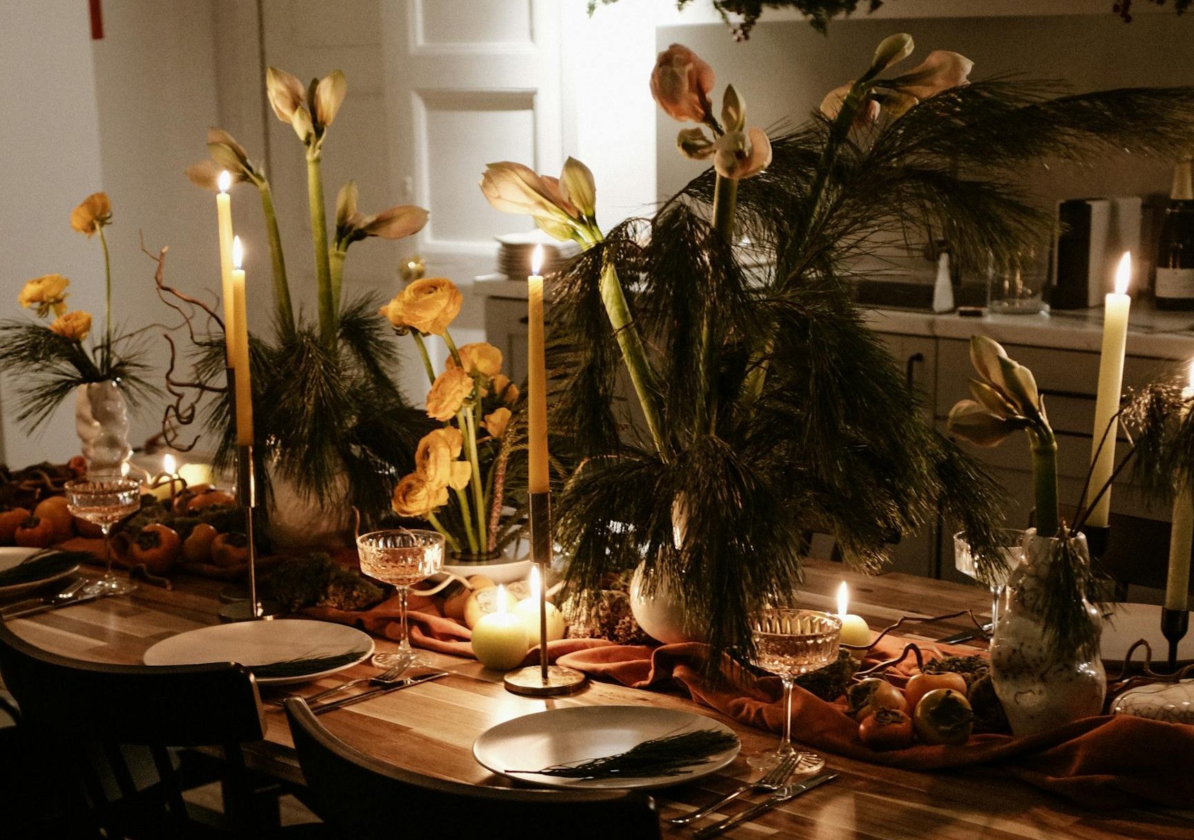 A beautifully arranged dining table with lighted candles and floral decor, perfect for festive dinners.