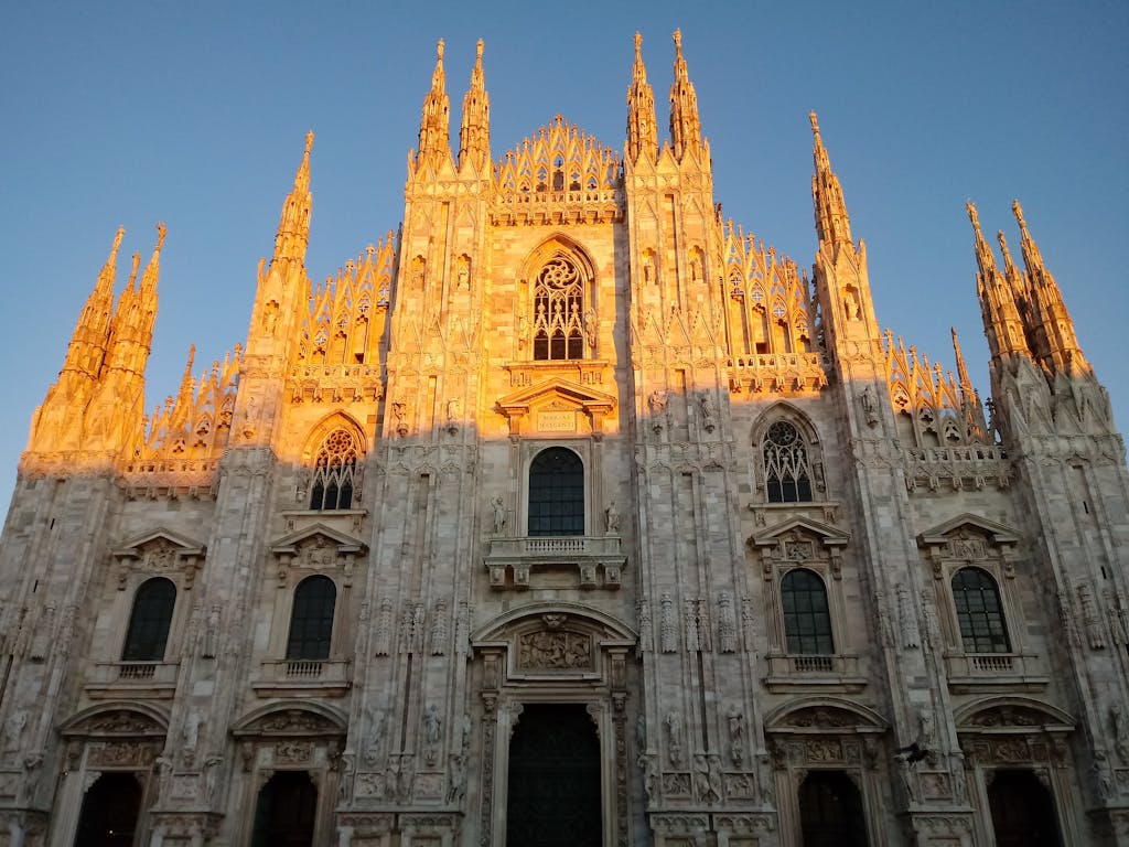 A magnificent view of the Milan Cathedral, glowing in the warm light of sunset.
