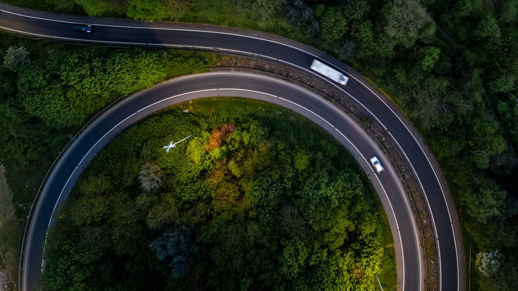 Stunning aerial view of a curved road surrounded by lush greenery in Leeds, United Kingdom.
